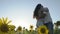 Happy in love couple enjoys each other standing in sunflowers field