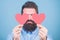 Happy in love. Love is amazing. Man bearded hipster with heart valentine card. Celebrate love. Guy attractive with beard