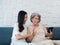 Happy lovely Asian senior woman, mother white hair and beautiful young female, daughter waving greeting at digital tablet screen.