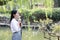 Happy lovely beauty Asia Chinese high school girl student smile enjoy free time in a park garden spring summer drink water cola