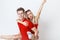 Happy lovely cheerful young couple in red casual look is hugging and smiling looking at camera on white background