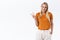 Happy, lovely feminine stylish blond woman in orange t-shirt trendy pants, hold hand in pocket, show peace or victory