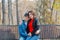 Happy lovers in the park on a bench in autumn.