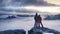 Happy lovers traveling together. Couple achieved the mountain peak while gentle snowing , watch lovely purple sunrise