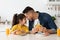 Happy Loving Arab Dad And Daughter Eating Sandwiches In Kitchen And Bonding