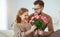 Happy loving   couple. husband gives his wife flowers at home