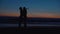 Happy loving couple on shore ocean at sunset in summer