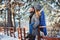 Happy loving couple walking in snowy winter forest, spending christmas vacation together.