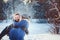 Happy loving couple walking in snowy winter forest, spending christmas vacation together.