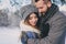 Happy loving couple walking in snowy winter forest, spending christmas vacation together. Outdoor seasonal activities.