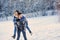 Happy loving couple walking in snowy winter forest, spending christmas vacation together. Outdoor seasonal activities.