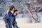 Happy loving couple walking in snowy winter forest, spending christmas vacation together. Outdoor seasonal activities.