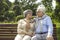 Happy loving senior couple sitting on bench and hugging looking into eyes