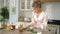 Happy luxury young woman making arugula salad in stylish modern kitchen.