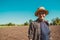 Happy male agro tourist in hat. Authentic rural farmer portrait. Agriculture worker. Vegetable garden. Rustic background. Country