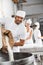 Happy Male Baker Pouring Flour In Kneading Machine