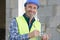 Happy male builder in hard hat with clipboard