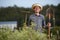 Happy male farmer with shovel and rake on the nature