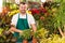 Happy male florist working flower gardening shop