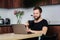 Happy male freelancer working at the dining table, drinking coffee