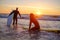 Happy male friends surfing during sunset