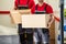 Happy Male Movers Holding Cardboard Boxes