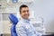 Happy male patient sitting on dental chair