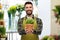 Happy male seller with plant at flower shop