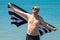 Happy man on the beach enjoys the freedom of the concept of rest and vacation