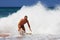 Happy man being splashed by a wave on the beach in Suances, Spain