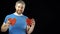 Happy man in blue tshirt holds two red heart shapes. Love, romance, dating, relationship concepts. Black background