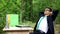 Happy man in business suit finishing work and relaxing in green beautiful forest