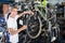 Happy man buyer checking tire on bicycle wheel