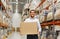 Happy man with cardboard parcel box at warehouse