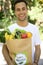 Happy man carrying a bag of organic food.
