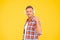 Happy man clench fist listening to music playing in modern earphones yellow background, audio