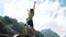 Happy man climbs a boulder and raises his hands up. Bouldering in the mountains