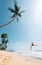 Happy man dangles on tropical palm tree swing