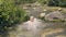 Happy man dipped and splash of water from mountain spring. Man bathing in river