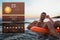Happy man with drink on inflatable ring in water and weather forecast widget. Mobile application