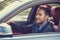 Happy man driver smiling driving sport blue car looking in a side mirror