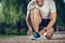 Happy man fixing shoelaces during training