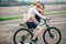 Happy man giving girlfriend a lift on his crossbar of bike on the beach