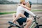 Happy man giving girlfriend a lift on his crossbar of bike on the beach