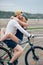 Happy man giving girlfriend a lift on his crossbar of bike on the beach