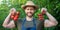 happy man greengrocer in straw hat with tomato bunch