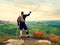 Happy man hiker holding medicine crutch above head, injured knee fixed in knee brace feature