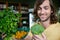 Happy man holding broccoli and bunch of herbs and in organic section