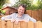 Happy man outdoor handsome smiling middle aged guy in home garden with wood hut