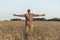 Happy man with outstretched arms against the background of a summer wheat field at sunset. Inspiration, freedom and joy